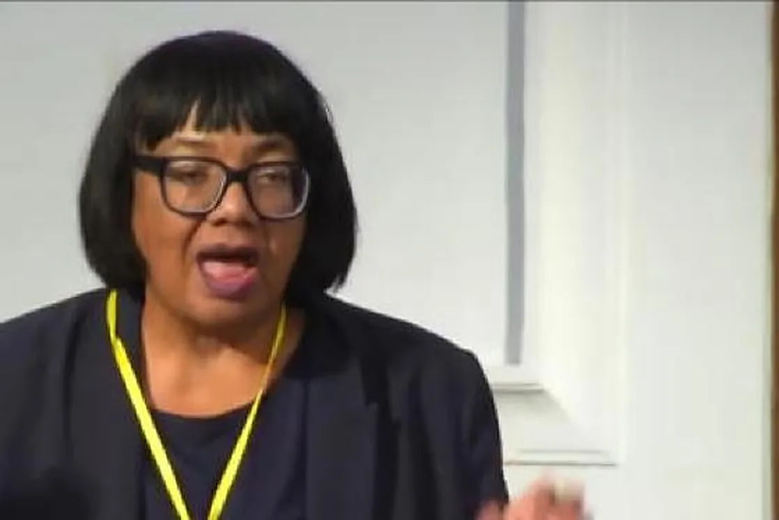 Diane Abbott MP, in a dark jacket and a yellow lanyard, speaking at the UK Reparations Conference.